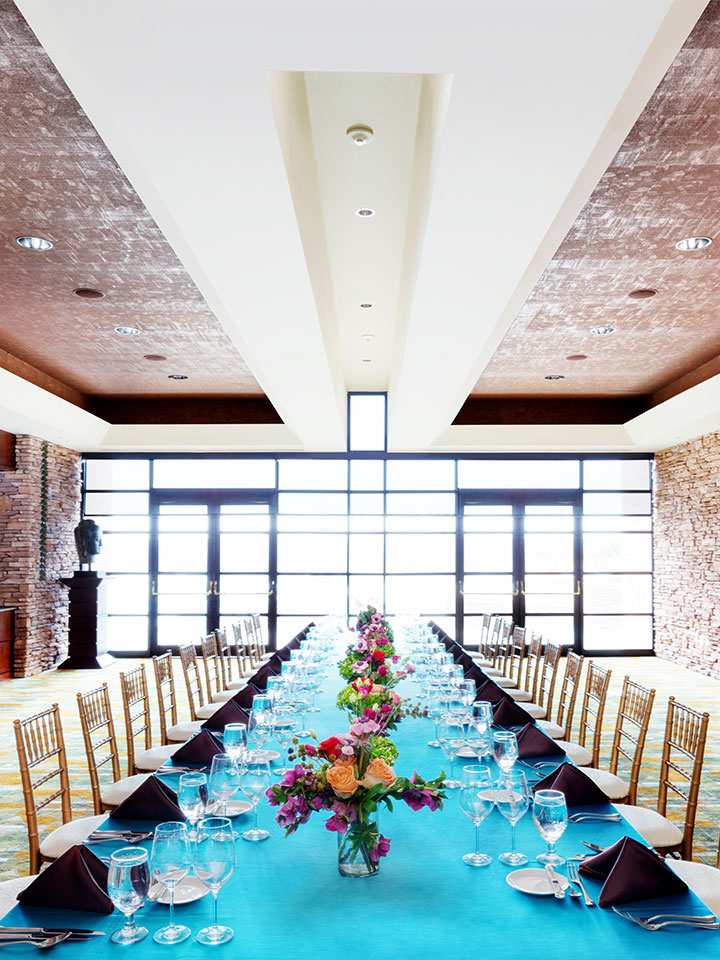 large dining table with blue table cloth and large windows
