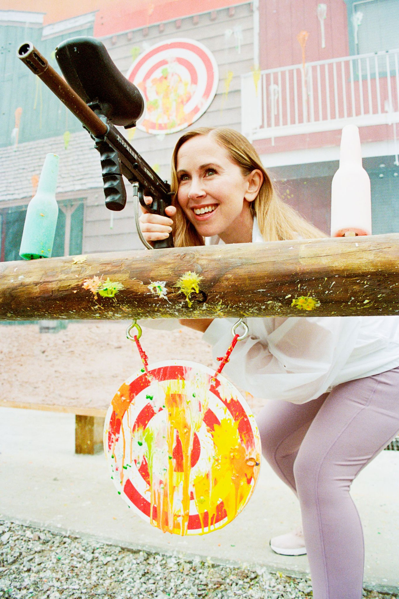 Open gallery overlay: a woman smiling while playing paintball